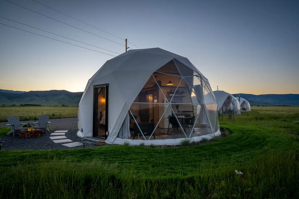 A glass-fronted geodesic dome glowing at dusk
